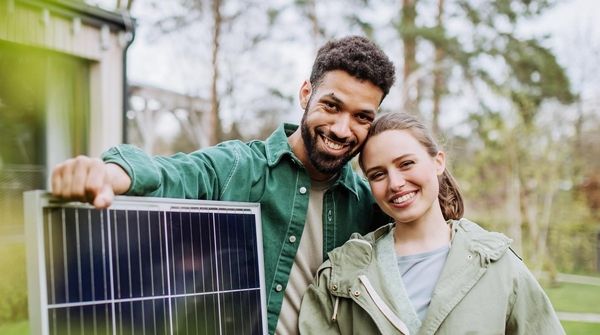Glückliches junges Paar mit Solarpanel