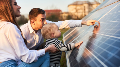Familie mit Kleinkind betrachtet Solarpanel