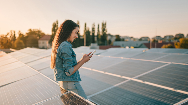 Frau auf Dach mit Solarpanels